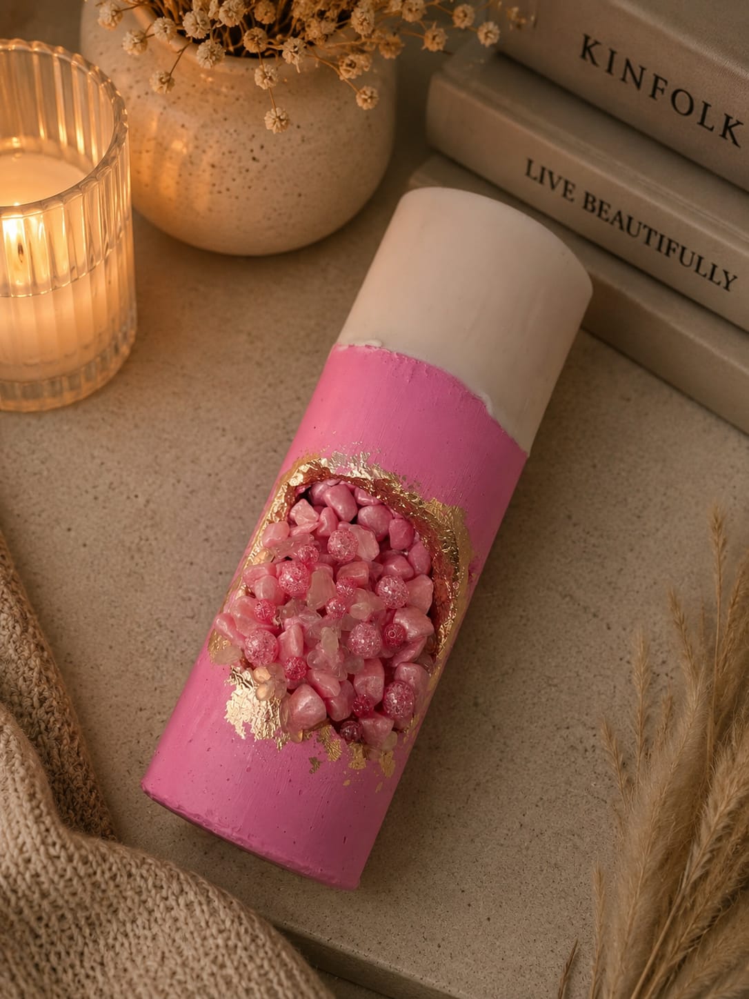 Brennende Luxus Geodenkerze in Rosa Brennende rosa Geodenkerze mit Kristallen auf dekorativem Tablett im warmen Interior