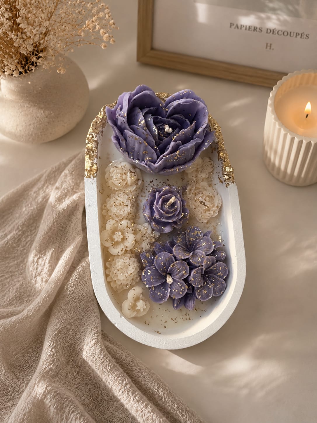 Dekorative Kerze mit violetten Sojawachsblumen Handgemachte Kerze im weißen Gips-Kashpo mit violetten Blumen aus Sojawachs und goldenen Akzenten