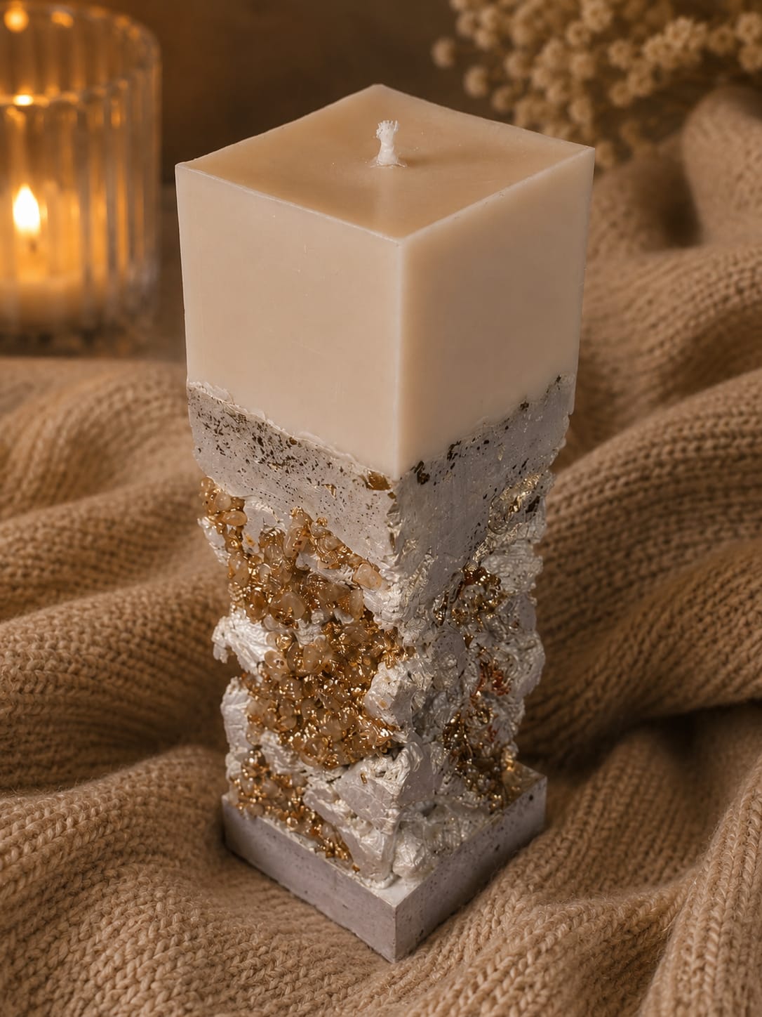 Luxus Duftkerze mit goldenen Kristallen Handgefertigte geometrische Kerze mit goldenen Kristall-Details in einem warmen, gemütlichen Interieur mit brennender Flamme.