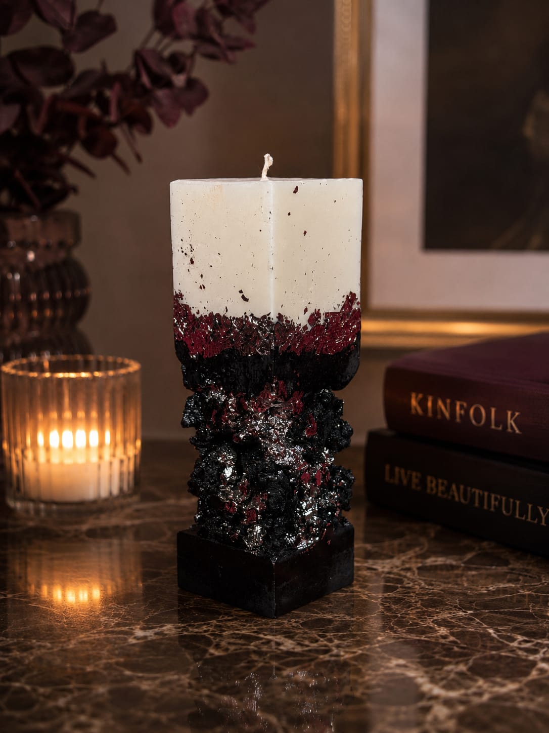 Brennende Luxus Betonkerze Silber Brennende schwarz-weiße Betonkerze mit Silberblatt und luxuriösem Butterduft in elegantem Wohninterieur.