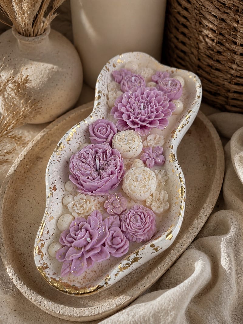 Handgemachte Blumenkerze in dekorativer Schale mit lila Blüten und Goldakzenten