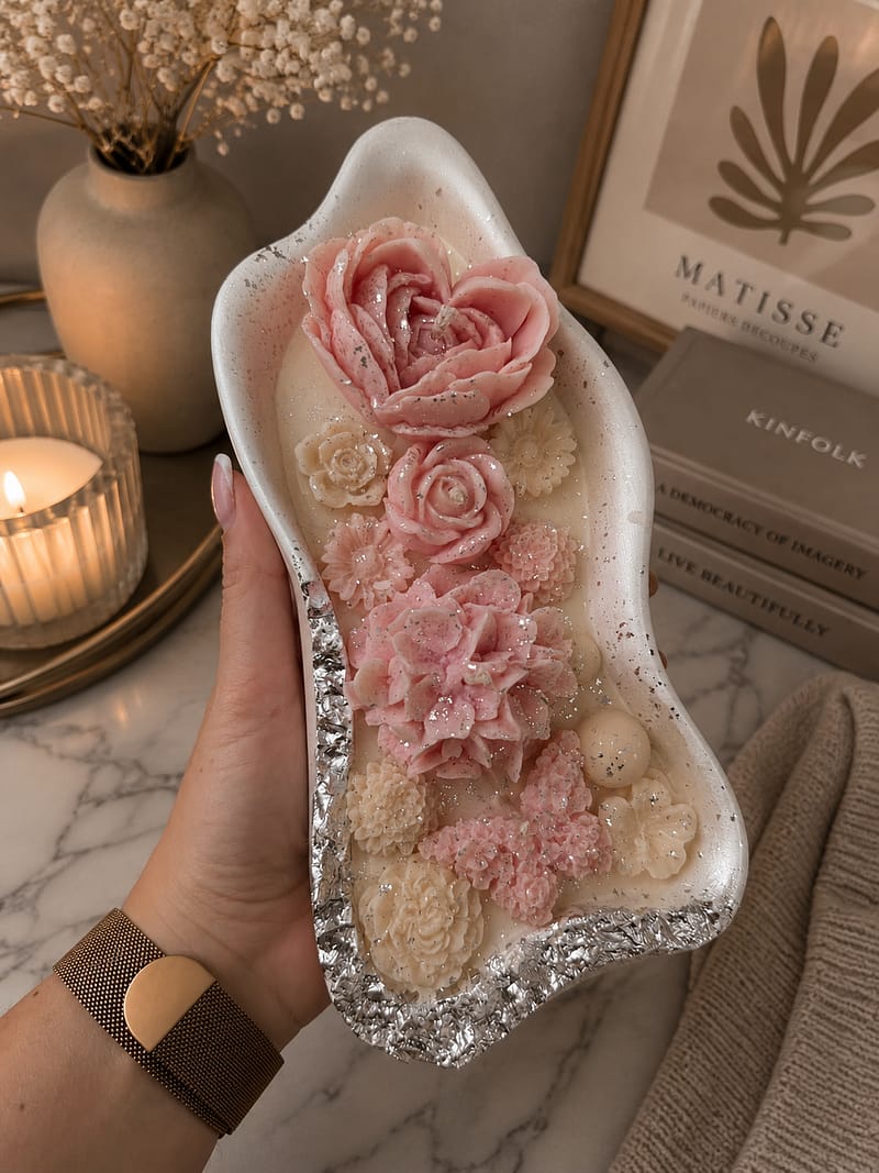 Dekorative Blumenkerze im weißen Gips-Kashpo mit rosa Wachsblumen und silbernen Details
